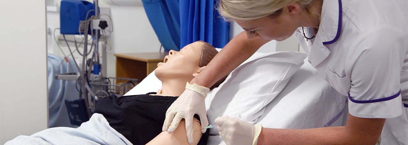 Student nurse practicing injections on a dummy.
