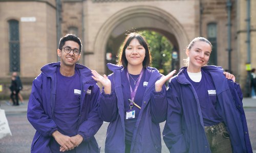 Three students in purple University of Manchester hoodies
