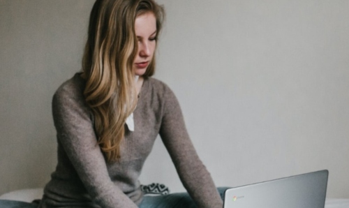 Student in bedroom on laptop